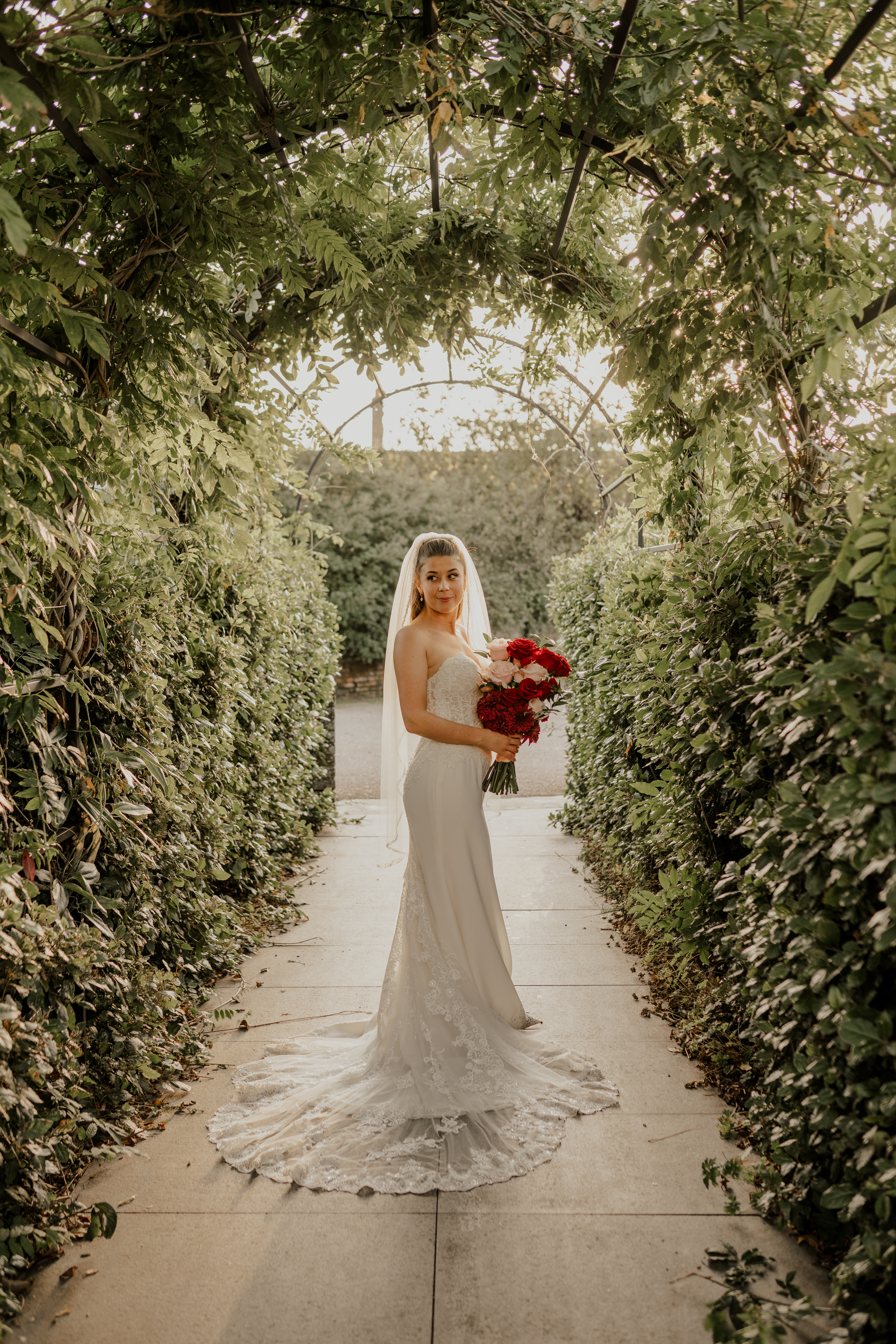 LaurenAndChris-125 (2) milling barn wedding scheme red and pink bouquet under foliage arch